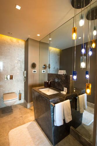 a bathroom with a sink and a toilet and a mirror at Sirene Luxury Hotel Bodrum in Yalıkavak