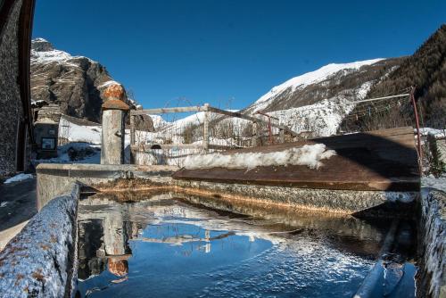 a pool of water with a snow covered mountain at Chalet Della Guida in Bardonecchia