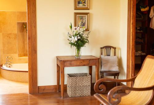 eine Vase mit Blumen auf einem Tisch mit Stuhl in der Unterkunft Villa Les Roses -8 pers- Piscine chauffée & cuisine d'été en Gascogne in Mézin