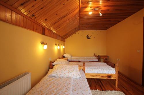 Dos camas en una habitación con techo de madera. en Apartmani Višnja, en Zlatibor