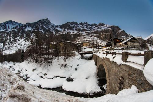 a bridge covered in snow with mountains in the background at Chalet Della Guida in Bardonecchia