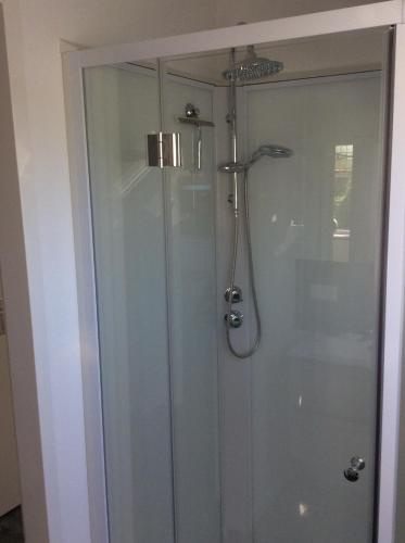 a shower with a glass door in a bathroom at de Bloemenhof in Ouddorp