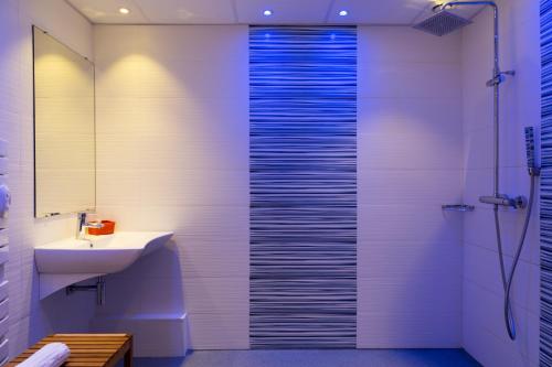 uma casa de banho com um chuveiro e um lavatório. em Logis Hôtel Corintel Bordeaux Est em Tresses