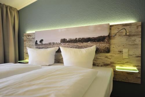 a hotel room with two beds with white pillows at Park Hotel Sellin in Ostseebad Sellin