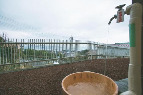 a bowl on a balcony with a water fountain at 熱海の海が一望できる温泉付貸別荘 満月あじろ mitsukiajiro in Atami