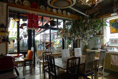 a dining room with a wooden table and chairs at The House Hostel in Sokcho