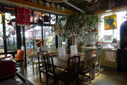 uma sala de jantar com uma mesa de madeira e cadeiras em The House Hostel em Sokcho