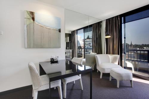 a living room with a table and white chairs at Corporate Living Accommodation Hawthorn in Hawthorn