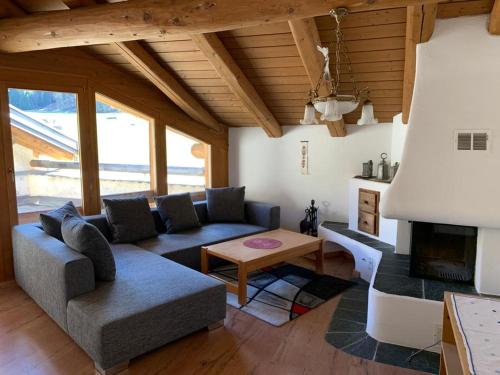 a living room with a couch and a fireplace at Ferienwohnung Jalet in Tschierv