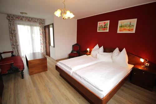 a bedroom with a large bed and a red wall at Ferienwohnung "Haus Falle" in Schiefling am See