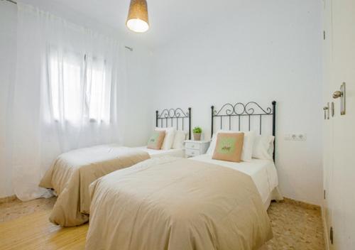 Dos camas en una habitación con paredes blancas. en VILLA SENSACIONES, en Tarifa