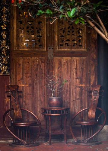 two chairs and a table with a potted plant on it at Lansheng yard in Xiamen