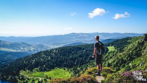 a man standing on top of a mountain looking at the valley at Chalet Le Cactus avec sauna privatif in Le Ménil