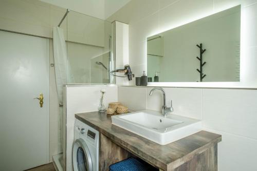 ein Badezimmer mit einem Waschbecken und einer Waschmaschine in der Unterkunft Heimelig im Allgäu in Lindenberg im Allgäu