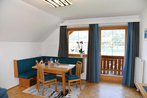una sala da pranzo con divano blu e tavolo e sedie di Haus Christina a Weissensee