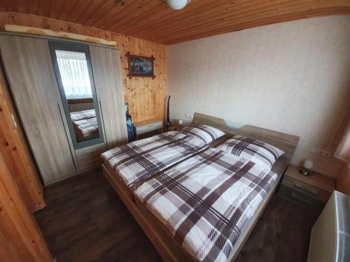 1 dormitorio con 1 cama en una habitación con ventana en Ferienhäuser in Allrode, en Thale