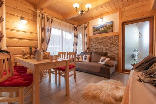 a living room with a table and a couch at Domki Pod Jemiołą in Zakopane
