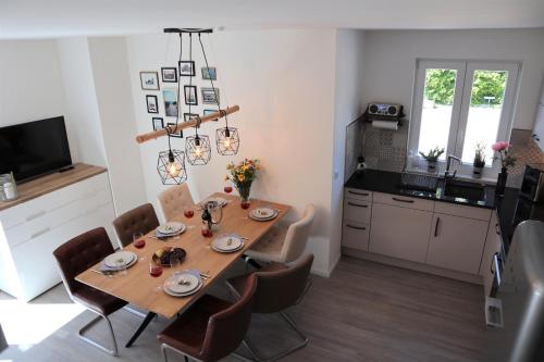 una cucina e una sala da pranzo con tavolo e sedie di Hafenperle am Suhrenpohl a Heiligenhafen