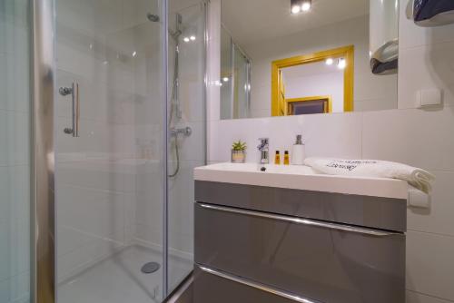 ein Bad mit einem Waschbecken und einer Dusche in der Unterkunft Apartament Lisowski CENTRUM in Zakopane