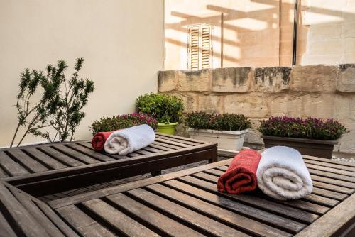 duas toalhas em cima de uma mesa de madeira em Valletta Ajkla Mansion em Valletta