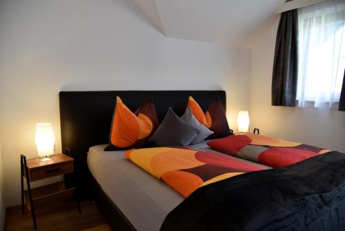 a bedroom with two beds with colorful pillows at Haus Christina in Weissensee