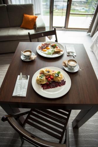a wooden table with two plates of food on it at Flinski Sport X SPA, Boutique X Art in Świeradów-Zdrój