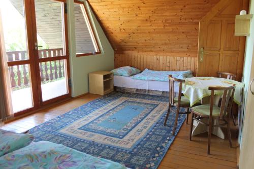 a room with a bed and a table in a cabin at Chata pod lesom Nová Baňa in Nová Baňa