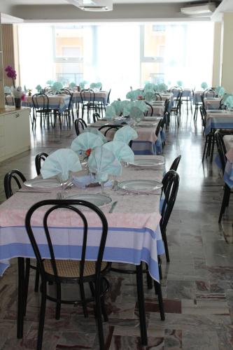 a row of tables with napkins on top of them at Hotel San Paolo in Rimini