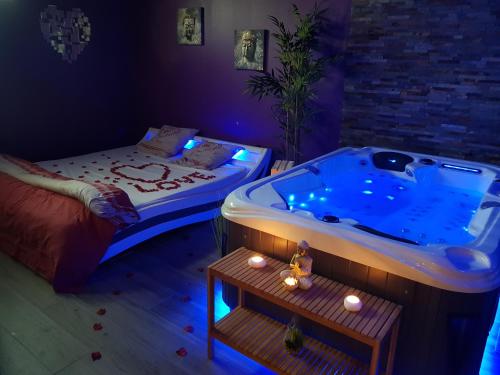 a room with a hot tub and a bed and a table at Lov'appart in Boulogne-sur-Mer