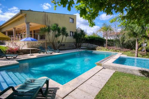 una piscina frente a una casa en Casa dos Carvalhos Guest House en Ponte da Barca