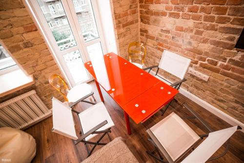 an orange table and chairs in a room with a brick wall at Kyiv Art Apartments near Golden Gate in Kyiv