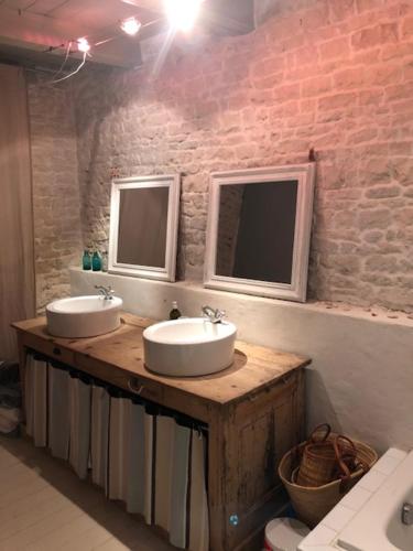 a bathroom with two sinks and two mirrors at L'Olivier de Milou in Le Bois-Plage-en-Ré