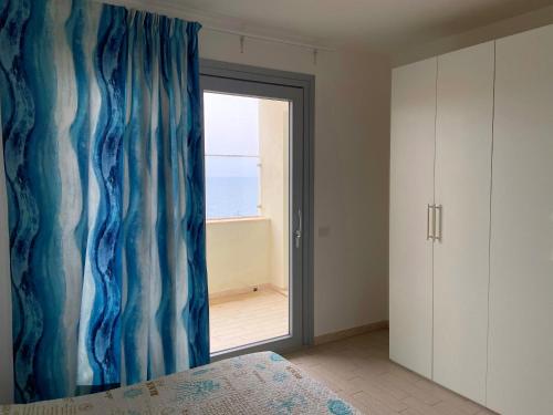 a bedroom with a window with a view of the ocean at Residenza Miramare in Castelsardo