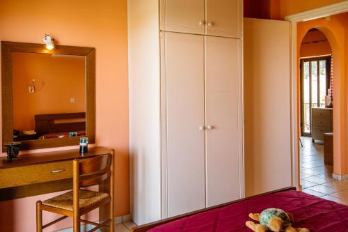 チィリヴィにあるDionysia's Apartmentsのデスク、キャビネット、鏡が備わる客室です。