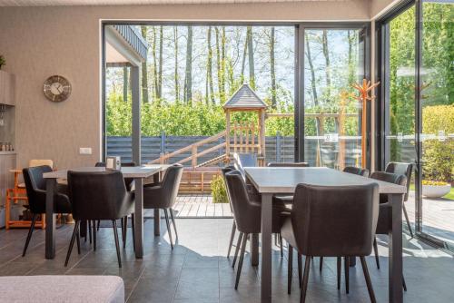 a dining room with tables and chairs and a large window at Vila Vitalija in Palanga