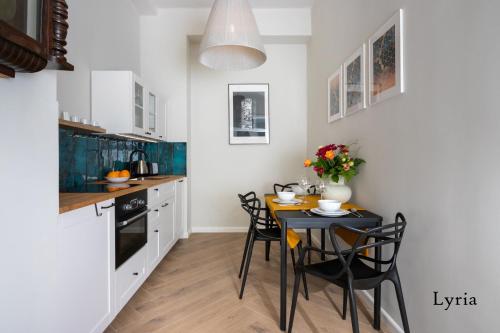 - une cuisine avec une table et des chaises noires dans la chambre dans l'établissement Brokilon House, à Cracovie