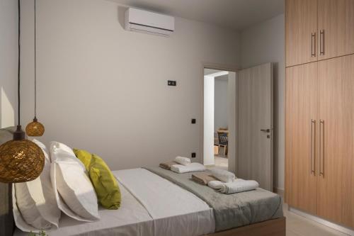 a white bedroom with a large bed with pillows at Aegean Breeze Luxury Apartments next to the sea in Maleme
