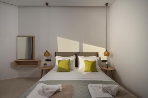 a bedroom with a large bed with yellow pillows at Aegean Breeze Luxury Apartments next to the sea in Maleme