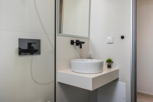 a white bathroom with a sink and a shower at Aegean Breeze Luxury Apartments next to the sea in Maleme