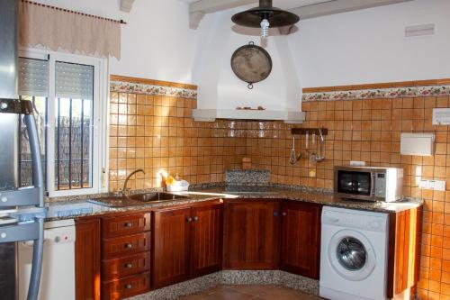cocina con fregadero y lavadora en Villas Dehesa Roche Viejo, en Conil de la Frontera