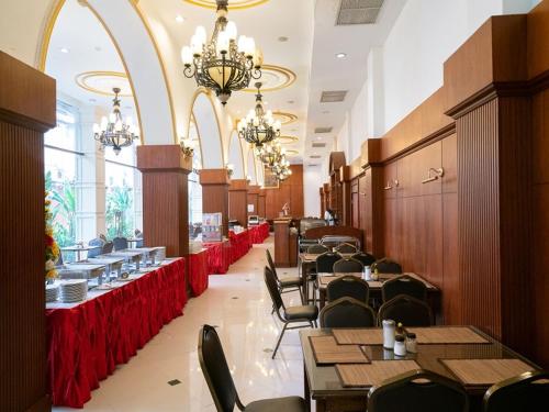 a dining room with tables and chairs and chandeliers at The Ecotel Bangkok in Bangkok