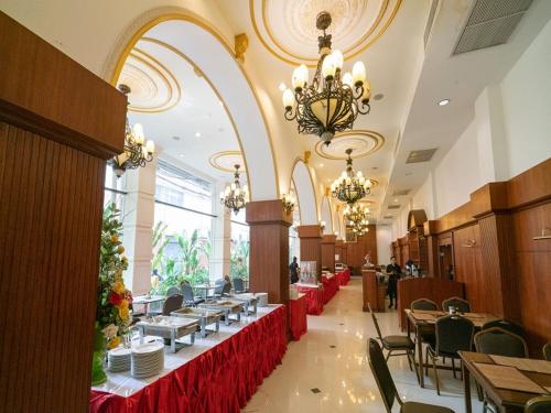 a dining room with tables and chairs and chandeliers at The Ecotel Bangkok in Bangkok