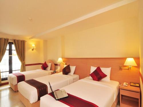 a hotel room with two beds and a desk at The Ecotel Bangkok in Bangkok
