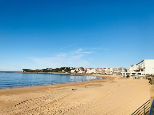una spiaggia con persone ed edifici e l'oceano di Appartement Plage Calme Centre 4personnes St Jean de Luz a Saint-Jean-de-Luz