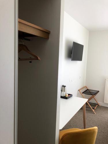 a room with a white table and a tv on a wall at Sure Hotel by Best Western Argentan in Argentan