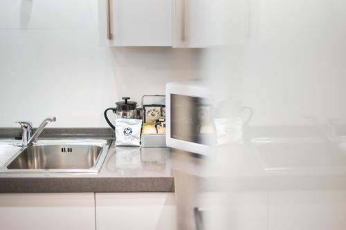 a kitchen with a sink and a microwave at Highland Apartments by Mansley in Inverness