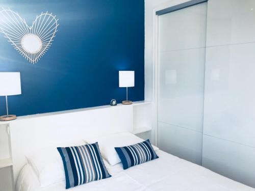 une chambre avec un lit blanc avec deux oreillers dans l'établissement Appartement Plage Calme Centre 4personnes St Jean de Luz, à Saint-Jean-de-Luz