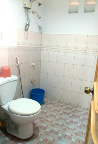 a bathroom with a toilet and a blue bucket at Sola Eleganza Apartelle in Manila