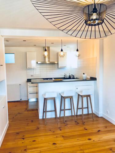 - une cuisine avec îlot de cuisine et tabourets de bar dans l'établissement Appartement Plage Calme Centre 4personnes St Jean de Luz, à Saint-Jean-de-Luz