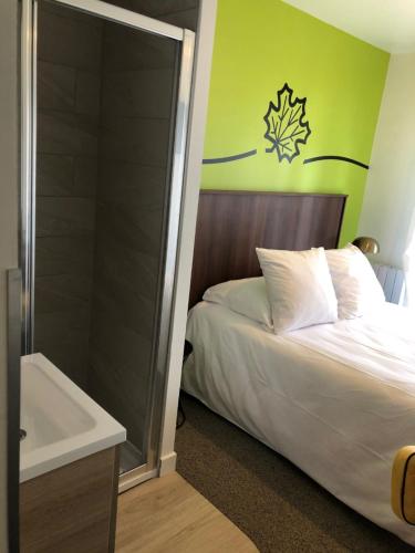 a bedroom with a bed and a shower and a sink at Sure Hotel by Best Western Argentan in Argentan